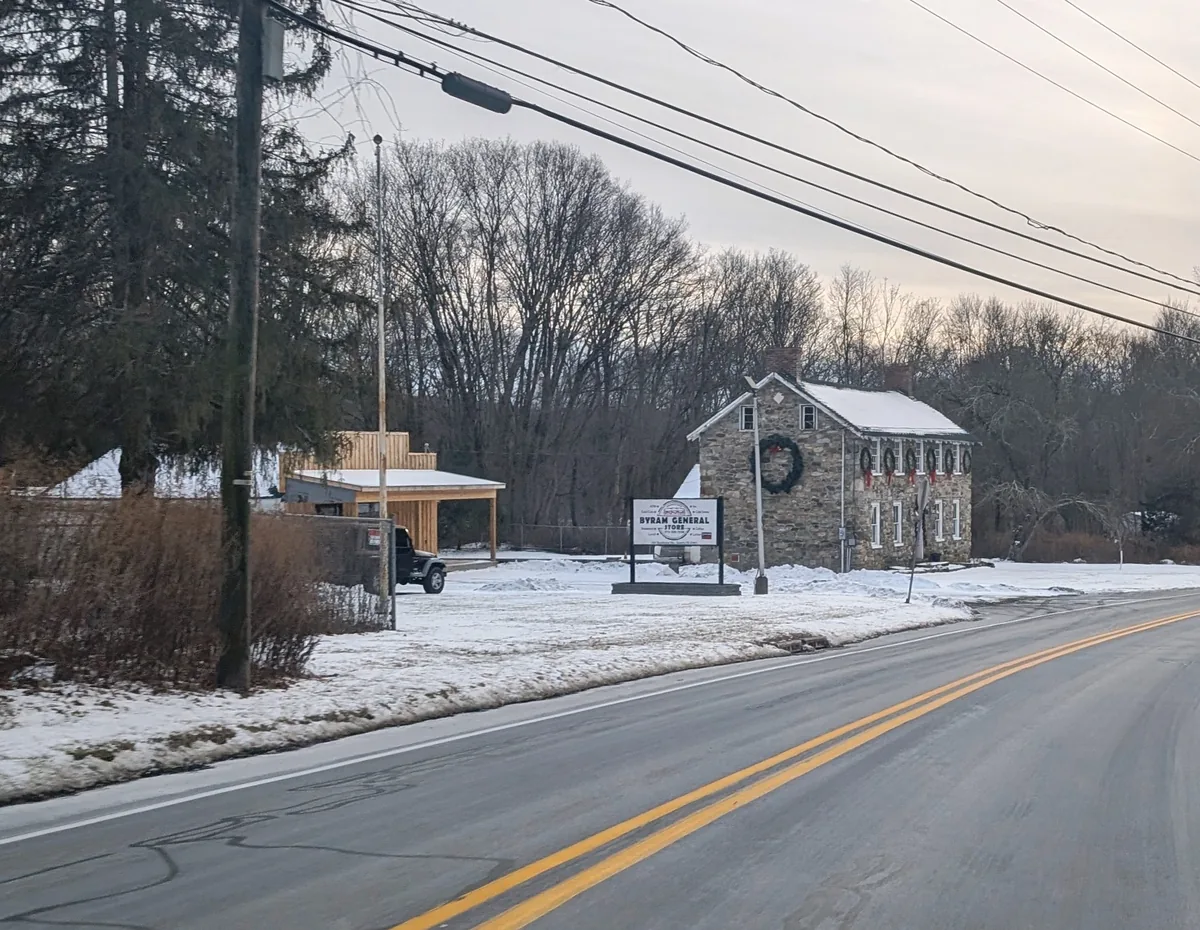 Old stone general store beside a winter road in Byram Township, New Jersey